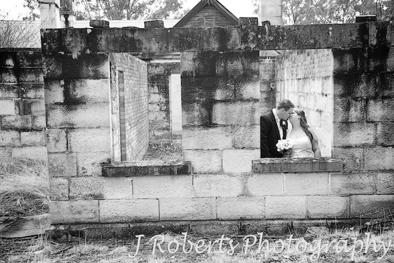 B&W of couple kissing in windows of old building facade - wedding photography sydney